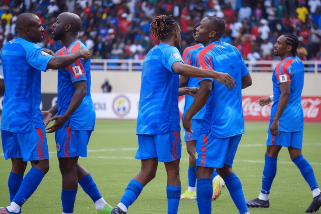 L'équipe nationale de la République Démocratique du Congo célébrant sa série de quatre matchs sans défaite, avec les supporters en arrière-plan.
