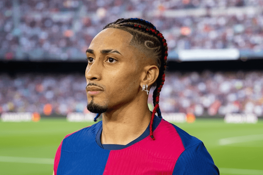 Raphinha dribblant un défenseur pendant un match.