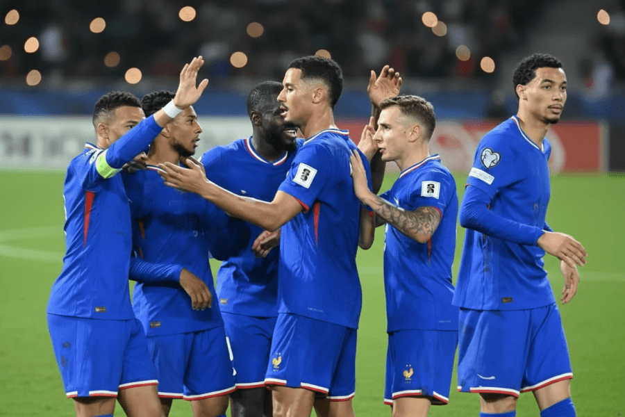 L'équipe de France célébrant un but avec Zidane en arrière-plan.