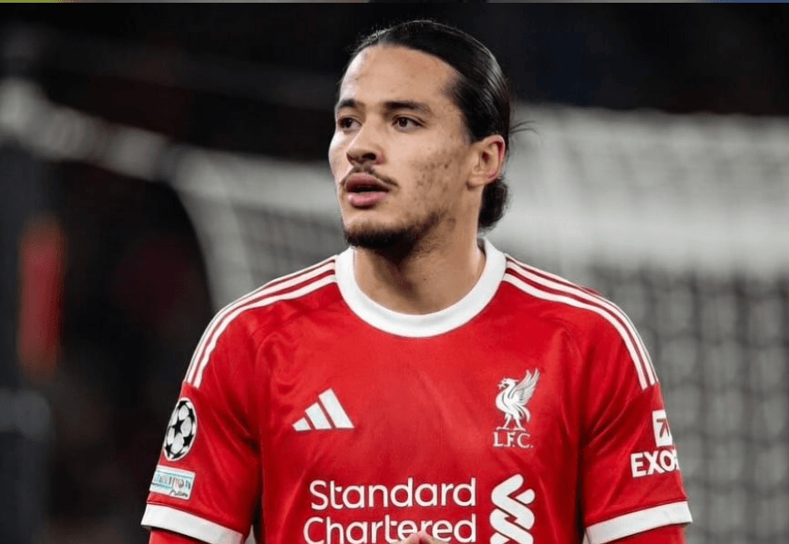 Stade Anfield de Liverpool sous la pluie lors d'un match de Premier League avec les tribunes pleines