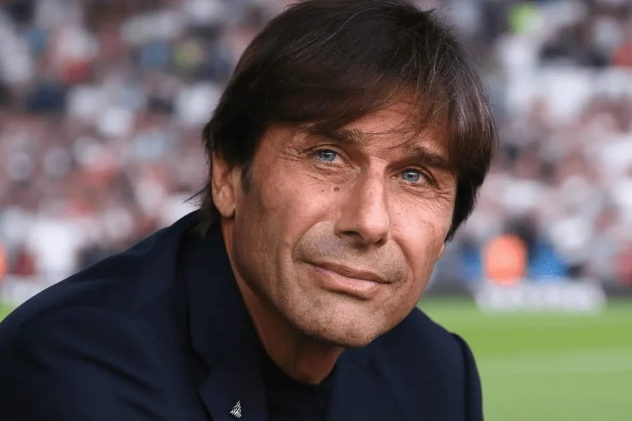 Antonio Conte discutant avec ses joueurs sur le terrain.
